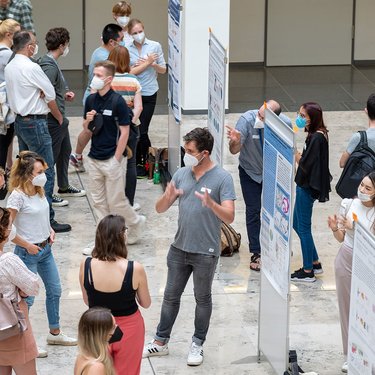 Diskutierende bei der Posterpräsentation im Lichthof des CCO (Charité Campus Mitte)